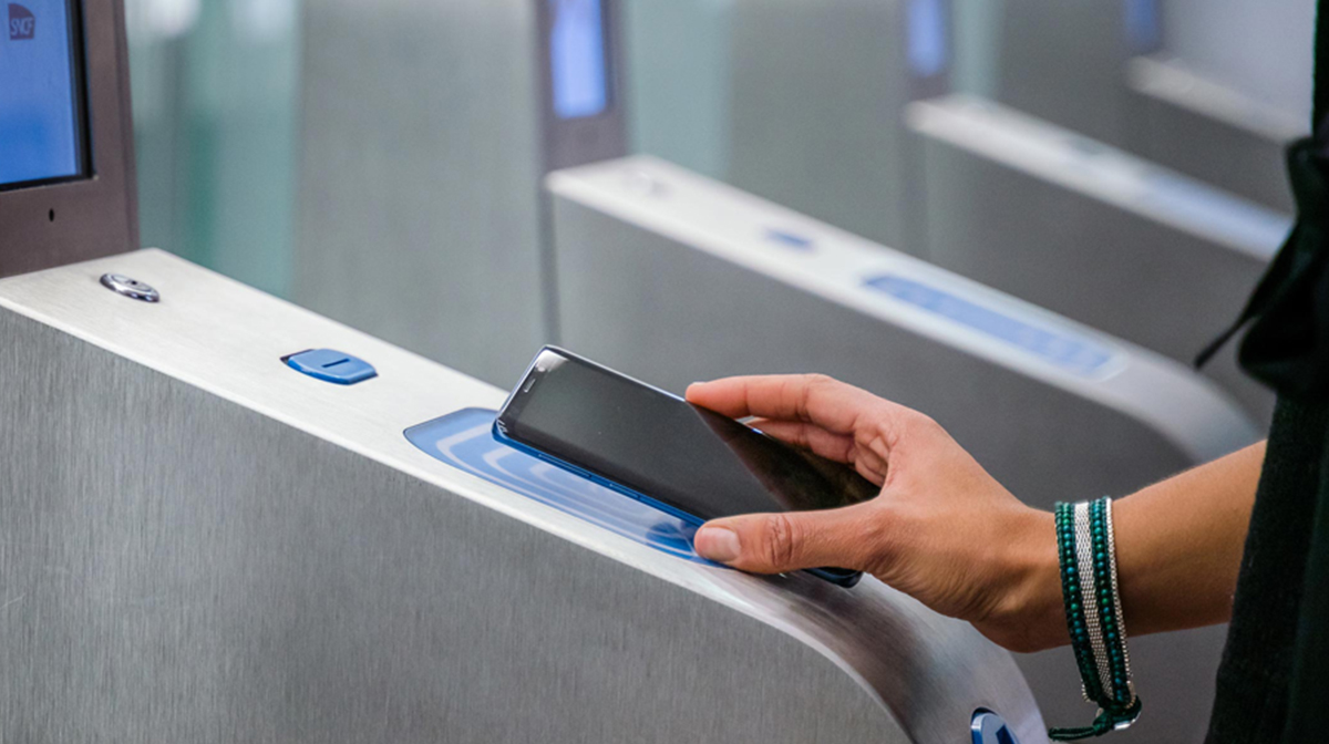 Photo d'une personne validant son titre de transport avec un smartphone à l'un des portique des transports en commun parisiens en Ile-de-France ; un service de Wizway Solutions pour RATP et SNCF, France ©Wizway-Solutions, DR