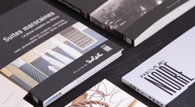 Livres de la maison d'édition Revue Noire ; livres posés sur une table lors d'une exposition intitulée 'Esprit Revue Noire, une collection fondatrice' par Hakanto Contemporary exhibitions, photo DR